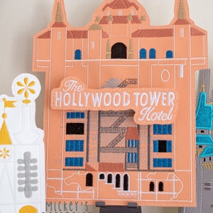 May include: A set of three embroidered felt patches featuring iconic Disney World hotels. The Hollywood Tower Hotel patch is peach colored with a white sign that reads "The Hollywood Tower Hotel".