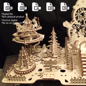 Puede incluir: Una escena de pueblo navideño de madera cortada con láser, con un muñeco de nieve, árboles y un carrusel. La escena incluye un castillo, escaleras y una valla. La imagen también muestra iconos de tipo de archivo (CDR, DXF, AI, SVG, PDF) y texto.
