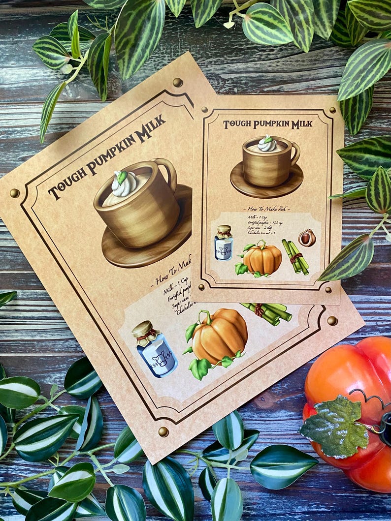 Op de afbeelding: Twee bruine papieren prints met de tekst "TOUGH PUMPKIN MILK" en illustraties van een kopje koffie, pompoen en ingredi&euml;nten. De prints zijn versierd met een bruine rand en messing klinknagels. Groene en witte bladeren omringen de prints.