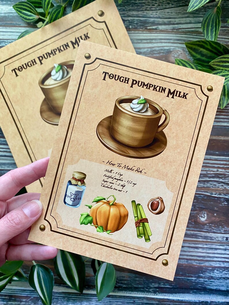 Op de afbeelding: Twee kaarten met de tekst "TOUGH PUMPKIN MILK" en een illustratie van een drankje in een houten mok met slagroom. E&eacute;n kaart toont een recept met een pompoen, kruiden en een fles melk.