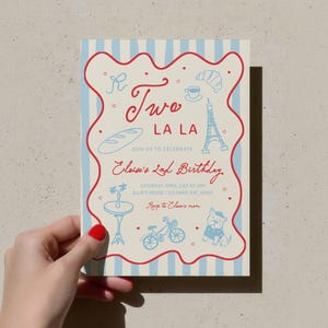 Puede incluir: Una tarjeta de invitación rectangular con un fondo a rayas azul claro y blanco. La tarjeta presenta ilustraciones rojas y azules de un cruasán, la Torre Eiffel y una bicicleta. El texto en la tarjeta dice "Two La La" y "Elsie's 2nd Birthday."