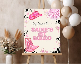 Könnte beinhalten: Ein rosafarbenes und weißes Willkommenszeichen für eine Rodeo-Party. Das Schild lautet "Willkommen zu Sadies 1. Rodeo". Auf dem Schild sind rosa Cowboystiefel, ein rosa Cowboyhut und eine rosa Discokugel zu sehen.