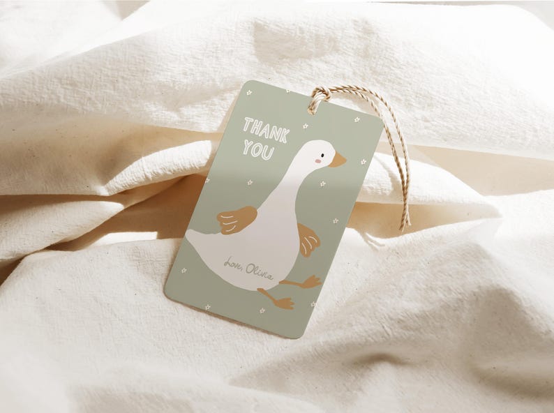 Pu&ograve; includere: Un'etichetta regalo rettangolare con un'illustrazione di un'oca dei cartoni animati. L'etichetta &egrave; verde chiaro con le parole "THANK YOU" in bianco. L'oca &egrave; bianca con dettagli marroni. Un cordino marrone &egrave; attaccato.