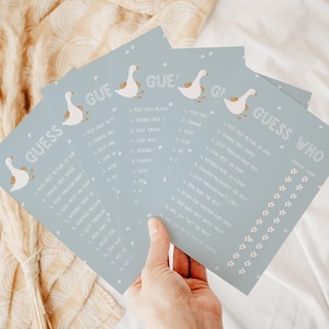 May include: A set of four blue baby shower game cards with white geese and flowers. The cards have the text "Guess Who" and a list of questions about the baby.