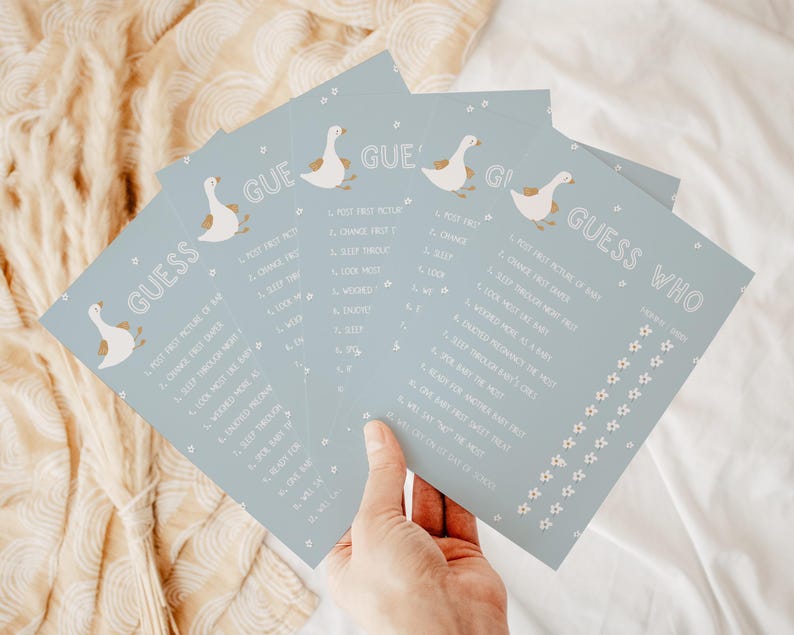May include: A set of four blue baby shower game cards with white geese and flowers. The cards have the text "Guess Who" and a list of questions about the baby.