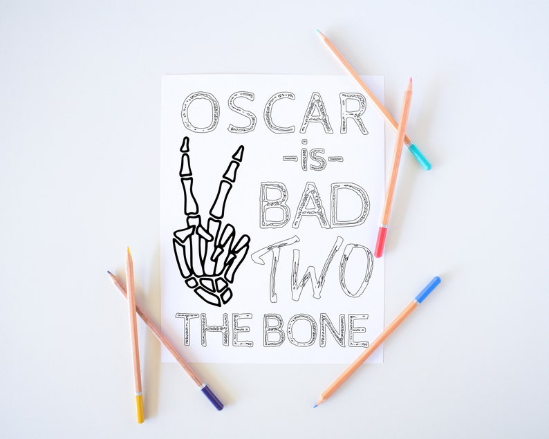 May include: A black and white printable coloring page with the text "Oscar is bad two the bone" and a skeleton hand making a peace sign.