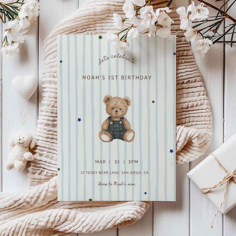 May include: A blue and white striped birthday invitation with the text "Let's celebrate" and "Noah's 1st Birthday." The invitation features a teddy bear illustration and the date, time, and location of the party.