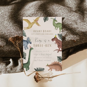 May include: A light pink dinosaur birthday party invitation with a green, brown, and yellow dinosaur illustration. The text reads "Roar! Roar! Let's party like dinosaurs. Knox is a Three-Rex. Saturday, March 21, 3:00 pm in Knox's backyard, 120 Prehistoric Ave, Boise, ID. RSVP to Knox's mom."