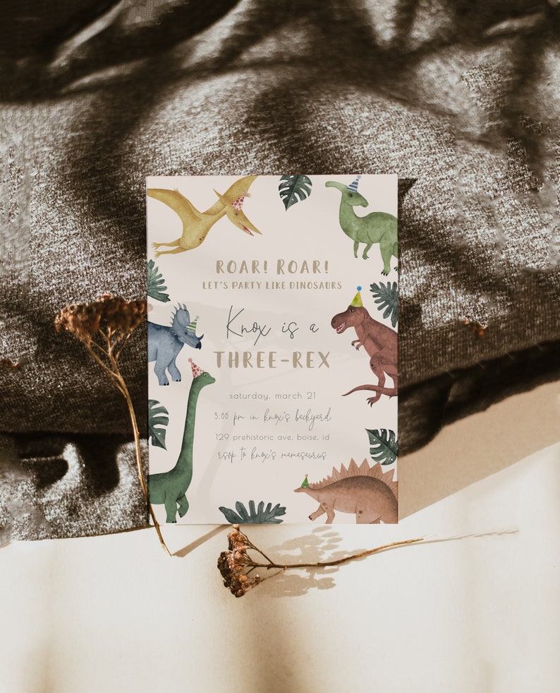 May include: A light pink dinosaur birthday party invitation with a green, brown, and yellow dinosaur illustration. The text reads "Roar! Roar! Let's party like dinosaurs. Knox is a Three-Rex. Saturday, March 21, 3:00 pm in Knox's backyard, 120 Prehistoric Ave, Boise, ID. RSVP to Knox's mom."
