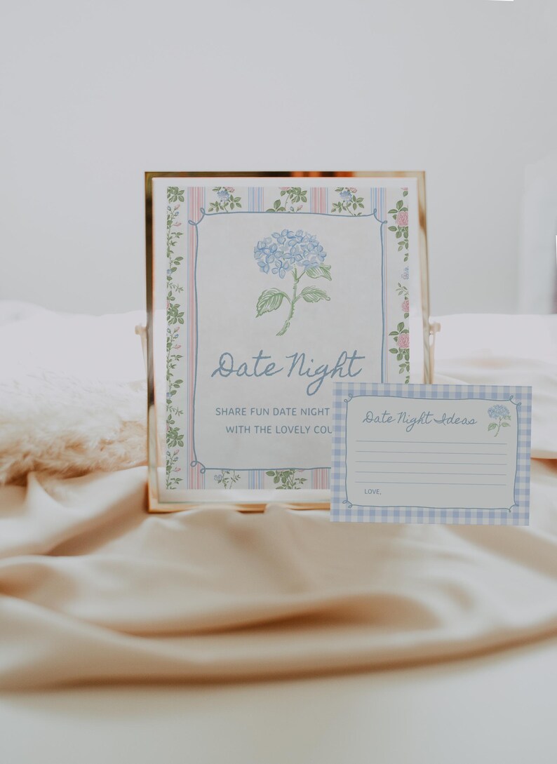 May include: A framed print with the words "Date Night" and a blue hydrangea illustration. A smaller card with "Date Night Ideas" is also visible. The design features a floral border and a soft color palette.