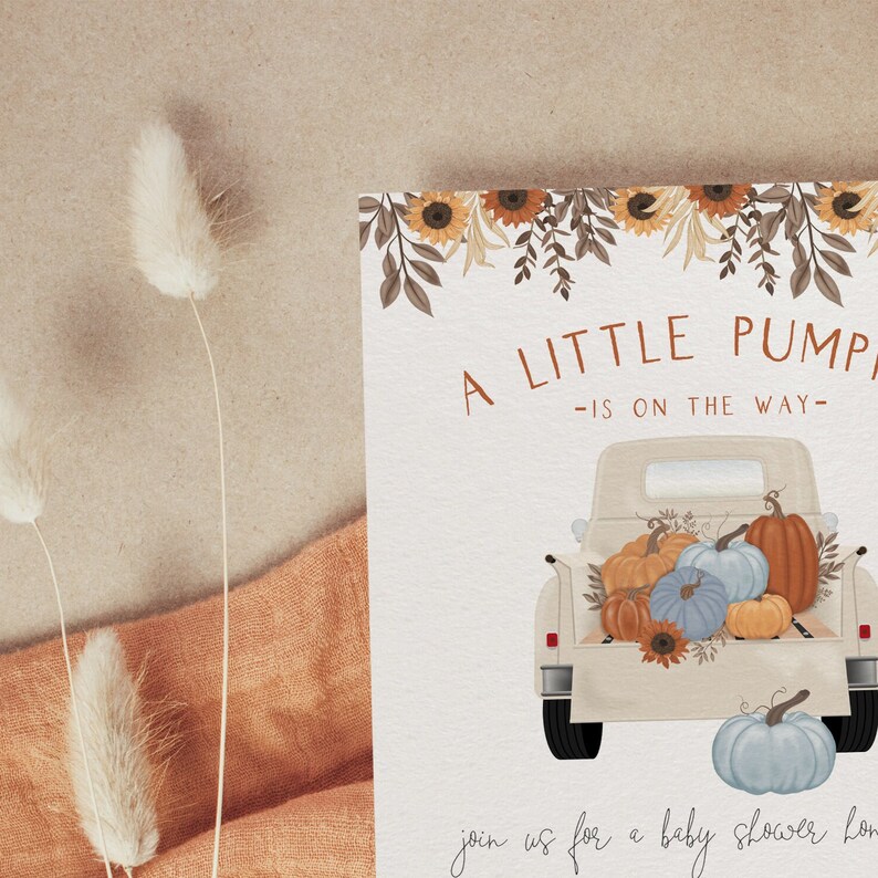 Pu&ograve; includere: Invito per baby shower con illustrazione ad acquerello. Il design presenta un camioncino vintage pieno di zucche nei toni dell'arancione, del blu e del giallo. Il testo recita "A Little Pumpkin is on the Way". Gli accenti floreali includono girasoli e foglie.