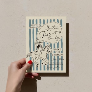 May include: A cowboy-themed invitation card. The design includes a cowboy on a horse and the words "Restin' Two-Tin Cowboy" in a speech bubble. The card is for Jack's 2nd birthday, on August 26th. The background has blue stripes.
