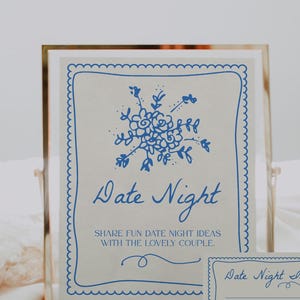May include: A white card with blue scalloped edges and a blue floral design. The card says "Date Night" and "Share fun date night ideas with the lovely couple". A smaller white card with blue scalloped edges says "Date Night Ideas".