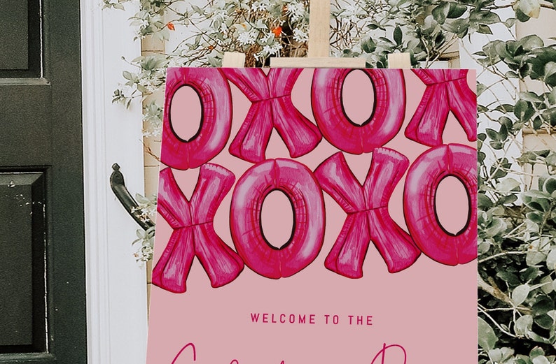 May include: Pink welcome sign with a pattern of pink XOXO balloons. The sign says "Welcome to the ..."