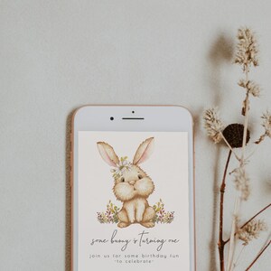 May include: A digital invitation with a cute cartoon bunny wearing a flower crown. The text reads "some bunny is turning one" and "join us for some birthday fun to celebrate".
