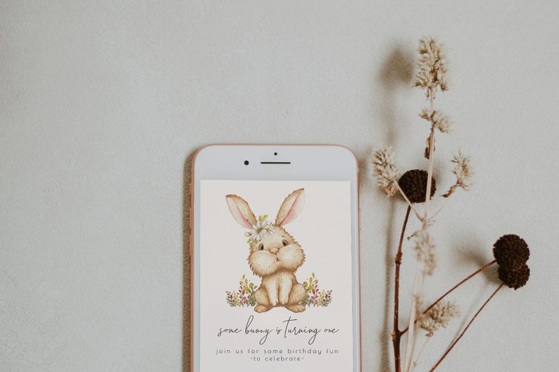 May include: A digital invitation with a cute cartoon bunny wearing a flower crown. The text reads "some bunny is turning one" and "join us for some birthday fun to celebrate".