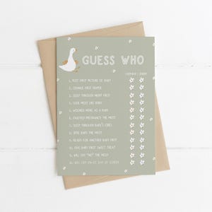 Pu&ograve; includere: Un biglietto per il gioco del baby shower con la scritta "Guess Who" e un'illustrazione di un'oca dei cartoni animati. Il biglietto &egrave; verde salvia con accenti floreali bianchi e un elenco di domande. &Egrave; posto su una busta marrone.