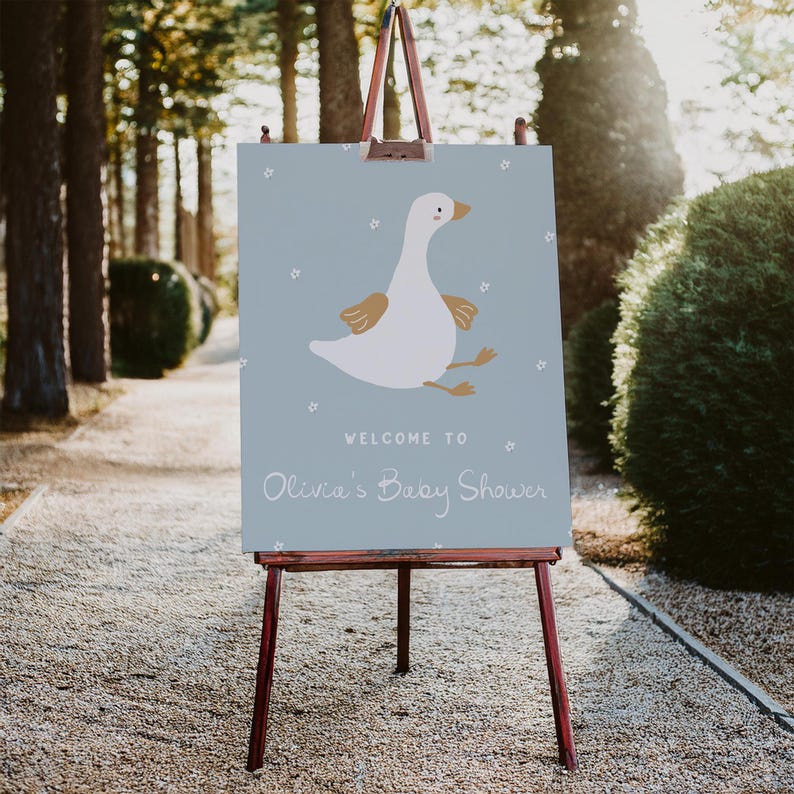 May include: A blue welcome sign with a white goose illustration and the text "Welcome to Olivia's Baby Shower".