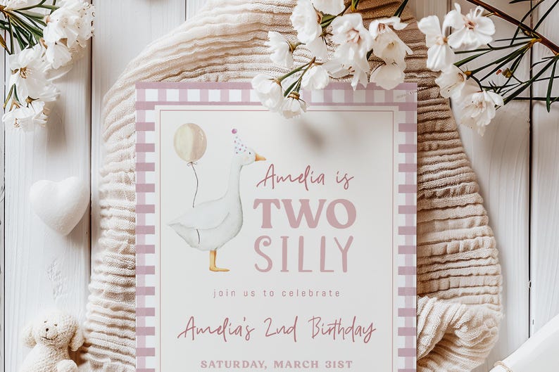 May include: Pink and white birthday party invitation with a white goose wearing a party hat and holding a balloon. The text reads "Amelia is Two Silly" and "Amelia's 2nd Birthday" with the date "Saturday, March 31st".