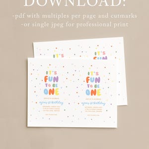 May include: Two white invitation cards with colorful text and confetti. The text reads "It's Fun to be One" in various colors. The cards also include details for Ezra's 1st birthday.