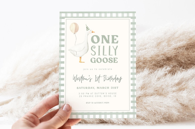 May include: A birthday invitation with a cartoon goose wearing a party hat and holding a balloon. The text reads "ONE SILLY GOOSE" and "Weston's 1st Birthday". The invitation has a light green gingham border and is held by a hand.