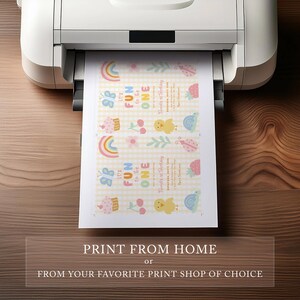 May include: A printer printing a sheet of paper with a colorful birthday design. The design includes rainbows, cupcakes, cherries, chicks, and snails. The text on the paper says "It's Fun to be One". The bottom of the image has the text "Print from Home or From Your Favorite Print Shop of Choice."