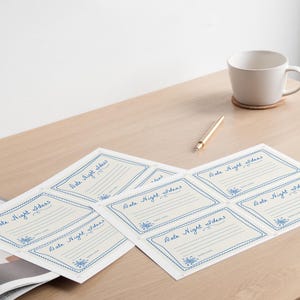 May include: A set of six blank cards with a blue and white border. The cards are labeled "Date Night Ideas" and have lines for writing.