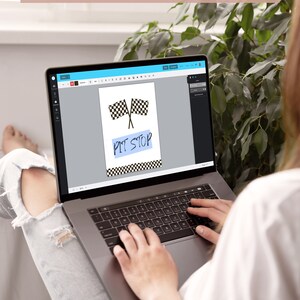May include: A person using a laptop to design a digital printable sign with a checkered flag and the text "Pit Stop".