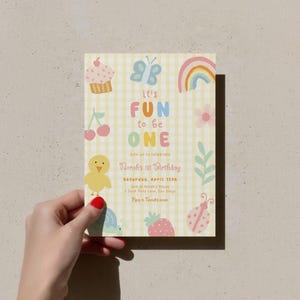 May include: A pastel-colored birthday invitation with a yellow gingham background. The invitation features a cupcake, butterfly, rainbow, flower, cherry, chick, turtle, strawberry, and ladybug illustrations. Text reads "It's Fun to be One" and includes event details.