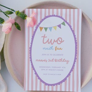 May include: A birthday invitation with pink and white stripes, featuring the text "two much fun." The invitation includes details for Maeve's 2nd birthday, with a decorative oval border and colorful bunting.