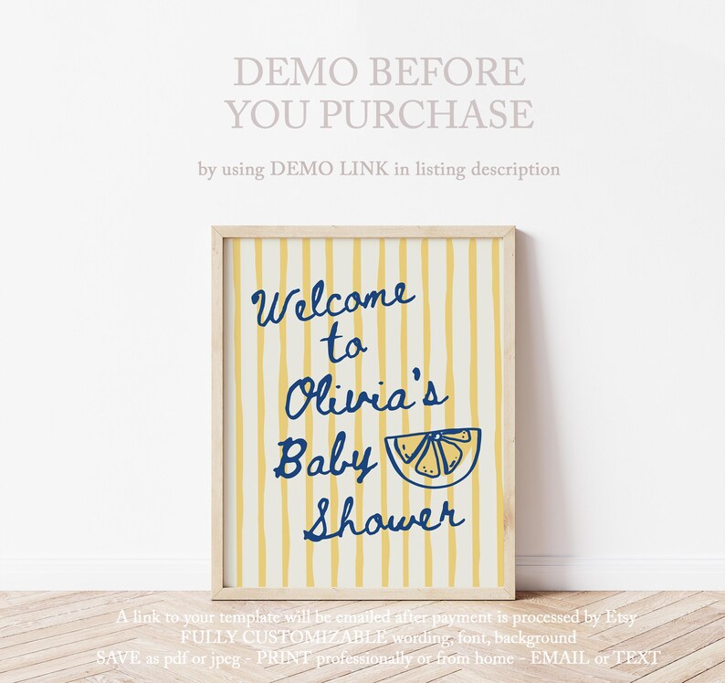 May include: A framed baby shower sign with a yellow and white striped background. The sign reads "Welcome to Olivia's Baby Shower" in navy blue script, with a lemon illustration. The sign is in a light wood frame.