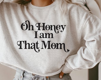 Puede incluir: Una sudadera gris con el texto "Oh Honey I am That Mom" impreso en negro.