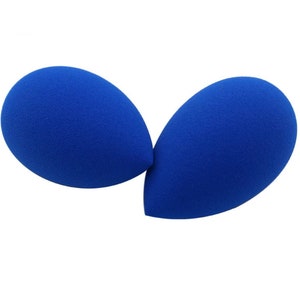 May include: Two blue makeup sponges in the shape of an egg. The sponges are soft and porous, ideal for applying makeup.