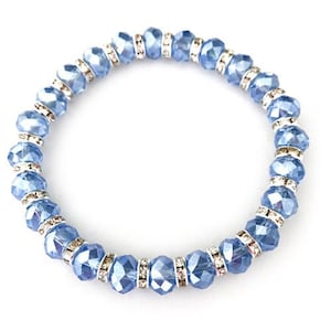 May include: A light blue crystal bracelet with silver accents. The bracelet is made of faceted beads with rhinestones.