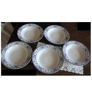 May include: Set of five white ceramic soup bowls with blue and gold floral designs. The bowls are round and have a slight lip.