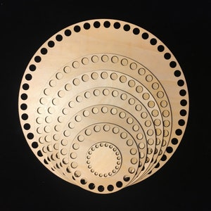 May include: A set of seven round wooden knitting looms with different diameters. The looms are nested inside each other, with the smallest loom in the center and the largest loom on the outside. The looms are made of natural wood and have a smooth finish.