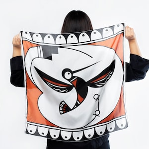 May include: A white silk scarf with a black and orange hummingbird design. The scarf has a black and white border with a repeating pattern of ovals.