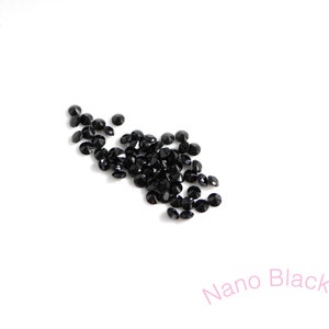 Puede incluir: Una dispersi&oacute;n de peque&ntilde;os diamantes de imitaci&oacute;n redondos negros sobre un fondo blanco. Nano Black.