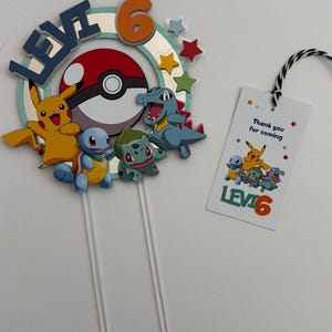 Pu&ograve; includere: Un topper per torta a tema Pok&eacute;mon con Pikachu, Bulbasaur, Squirtle e Charmander. Il topper include una Pok&eacute; Ball rossa e bianca, un cerchio blu e verde con il nome "Levi" e il numero "6" in arancione. Un'etichetta separata dice "Grazie per essere venuto" con un'immagine di Pok&eacute;mon e "Levi 6".