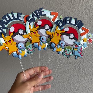 Pu&ograve; includere: Tre topper per torte colorati con i personaggi Pok&eacute;mon Pikachu, Squirtle e Bulbasaur. Ogni topper ha una Pok&eacute; Ball blu, rossa e bianca, un Pikachu giallo e un numero 7. I topper sono su bastoncini di plastica trasparente.