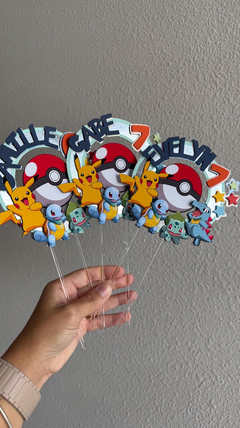 Pu&ograve; includere: Tre topper per torte colorati con i personaggi Pok&eacute;mon Pikachu, Squirtle e Bulbasaur. Ogni topper ha una Pok&eacute; Ball blu, rossa e bianca, un Pikachu giallo e un numero 7. I topper sono su bastoncini di plastica trasparente.