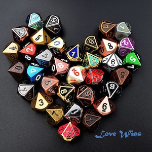 Op de afbeelding: Een hartvorm gemaakt van kleurrijke metalen dobbelstenen met zwarte nummers. De dobbelstenen zijn in een hartvorm gerangschikt op een zwarte achtergrond. De tekst "Love Wins" is in blauw onder de dobbelstenen geschreven.