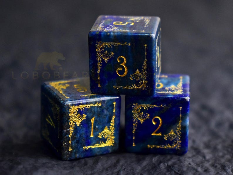 Peut inclure: Trois d&eacute;s bleus avec des filigranes dor&eacute;s et des chiffres. Les d&eacute;s sont empil&eacute;s, affichant les chiffres 1, 2 et 3. Les d&eacute;s ont un fond bleu fonc&eacute; et des accents dor&eacute;s. Id&eacute;al pour les jeux de soci&eacute;t&eacute;.