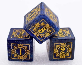 May include: Three blue dice with gold numbers and intricate designs. The dice are made of lapis lazuli and have a speckled appearance.