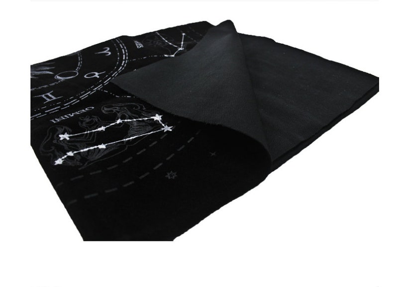 May include: Black felt cloth with a white zodiac design. The design includes the constellations Gemini, Cancer, and Leo, as well as a clock face with Roman numerals.