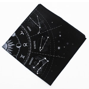 May include: Black fabric with a white zodiac wheel design. The wheel features the constellations for Aries, Taurus, and Gemini.