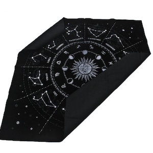 May include: Black velvet cloth with a white zodiac wheel design featuring the constellations and astrological symbols. The cloth is folded in half, revealing the black velvet backing.