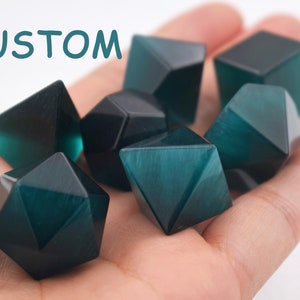 May include: A set of six teal green dice with a variety of shapes, including a pyramid, a cube, and a dodecahedron. The dice are made of a translucent material and have a slightly iridescent finish.