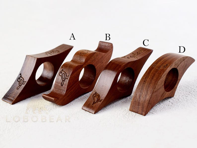 May include: Four wooden bookends with a bird design and the word "Taylor" engraved on three of them. The bookends are brown and have a smooth finish.