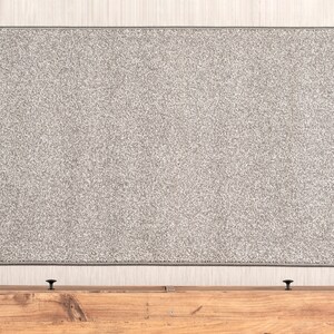 May include: A gray fabric headboard with a wooden frame and two black knobs.